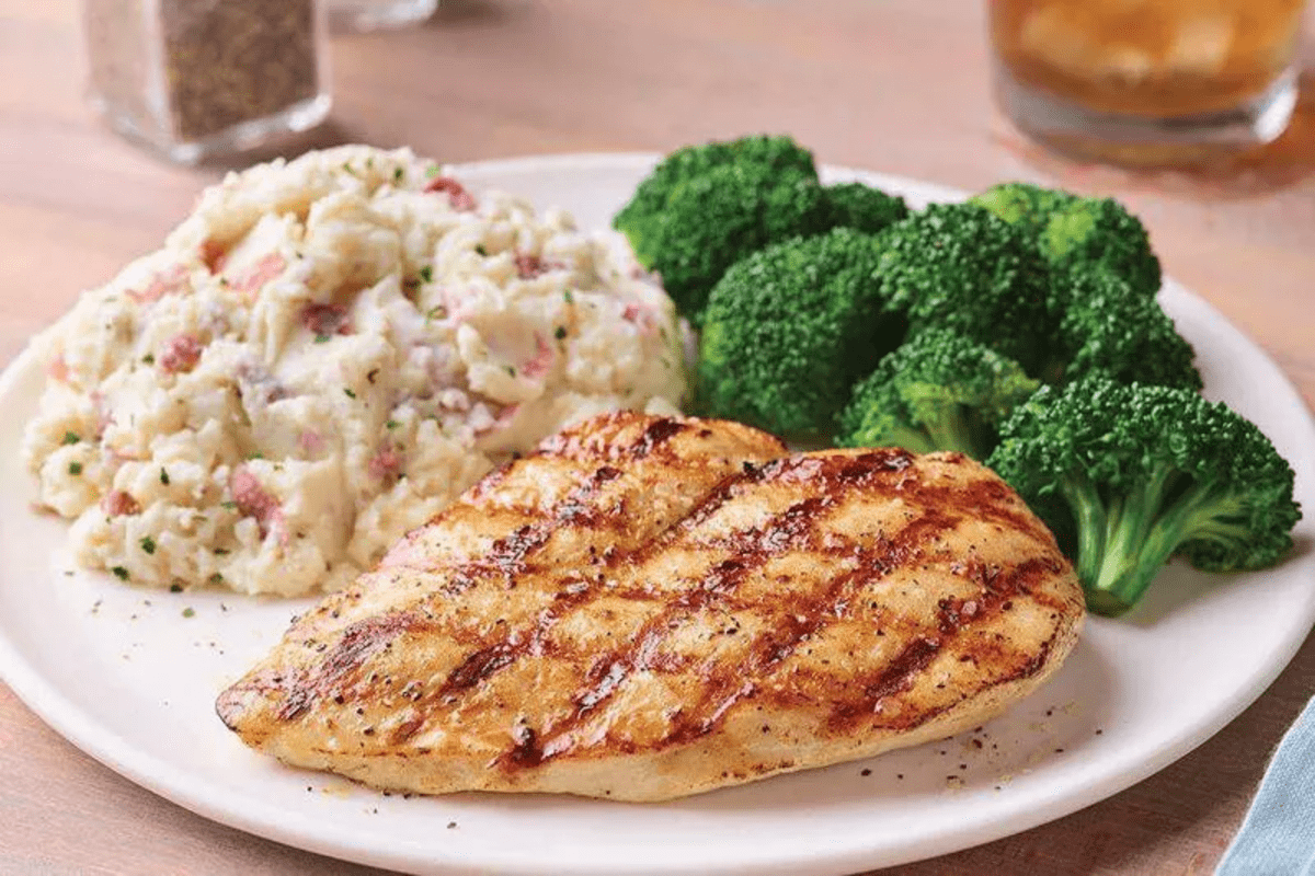 A plate with grilled chicken, broccoli and mashed potatoes.