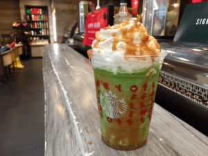 A green starbucks drink with whipped cream on top