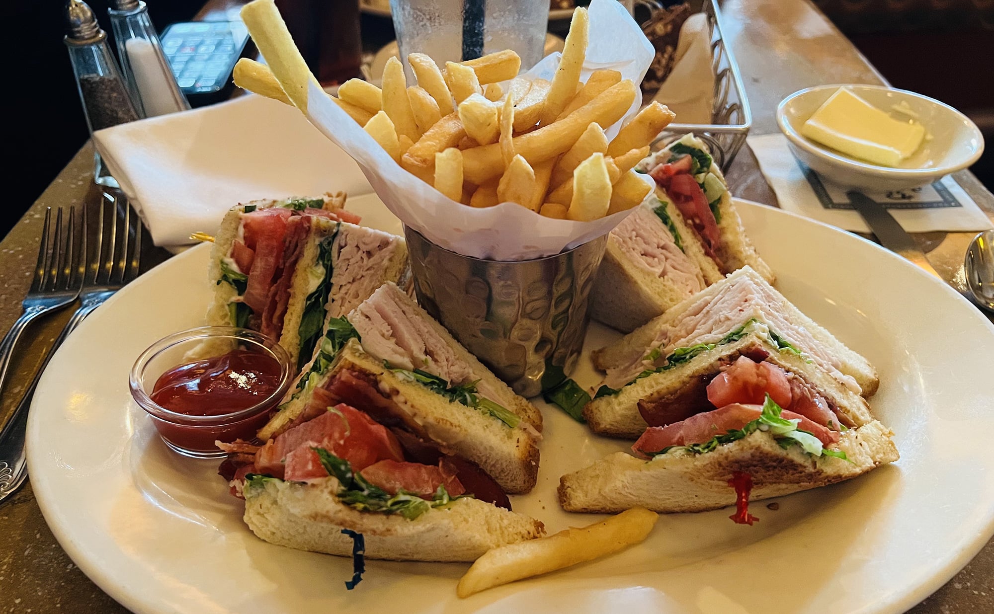 A plate with sandwiches and fries on it.