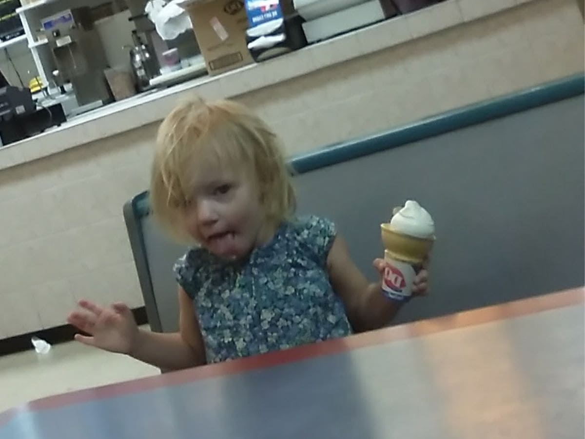 A little girl enjoying a cheap ice cream cone.