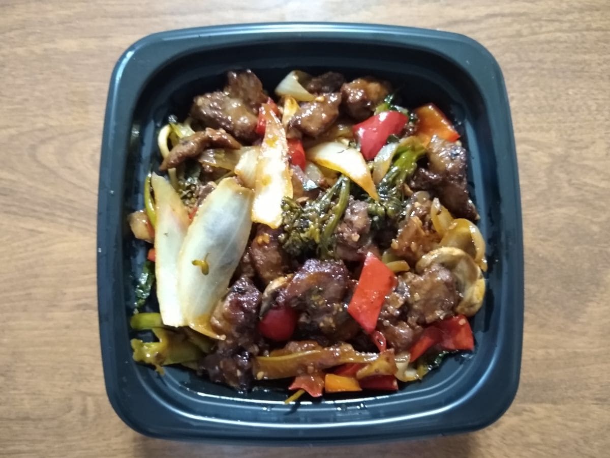 Affordable and nutritious Chinese stir fry, served in a black container on a table.