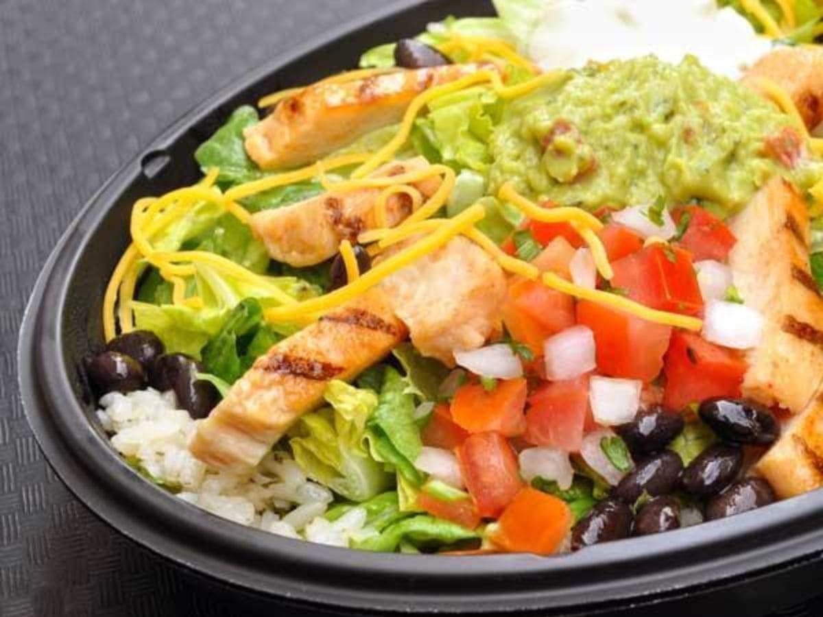 A cheap and healthy fast food option featuring a bowl of chicken salad with rice and beans.