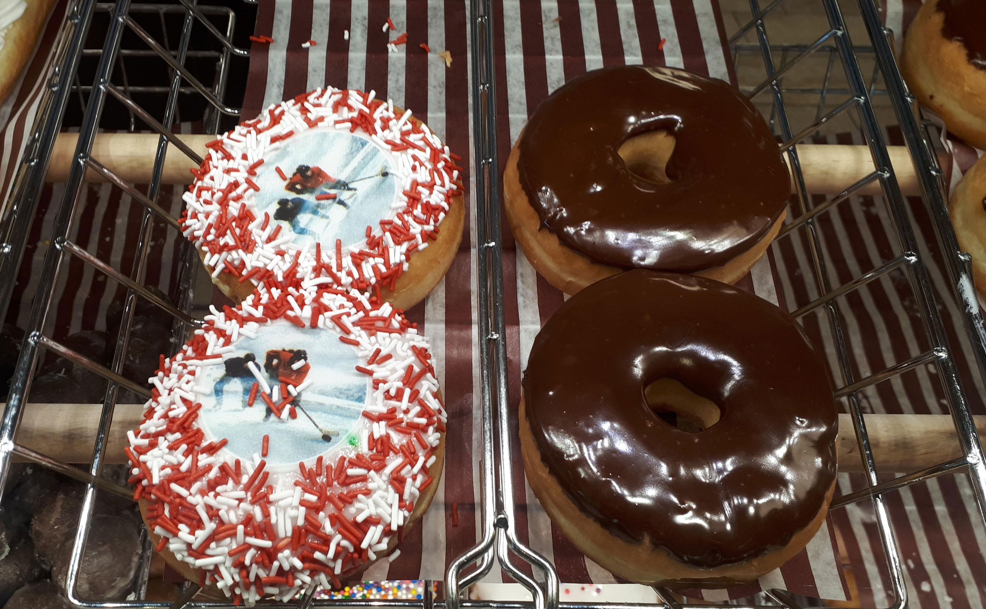 A rack of donuts with red and white icing.