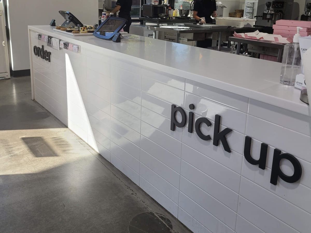 A white counter with a sign that says pick up.