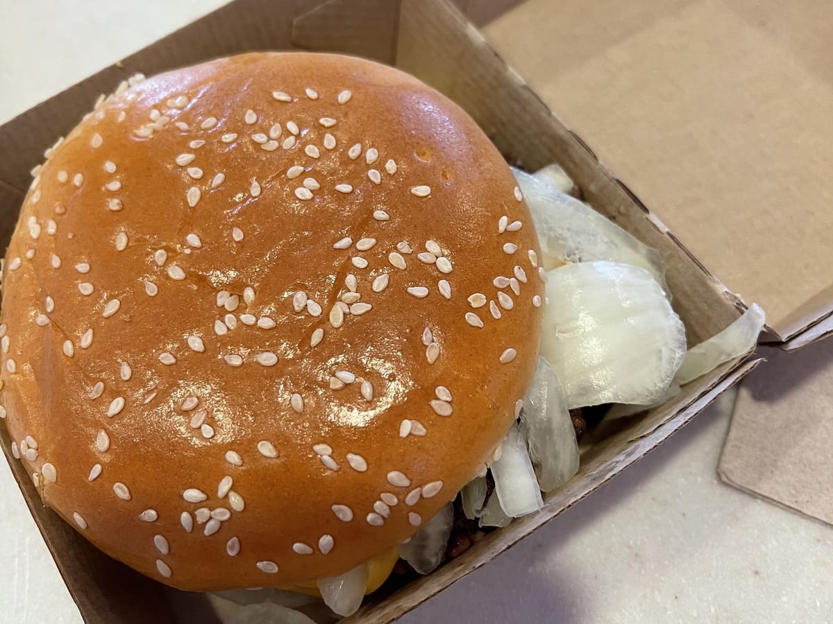 A McDonald's burger with cheese in an open box